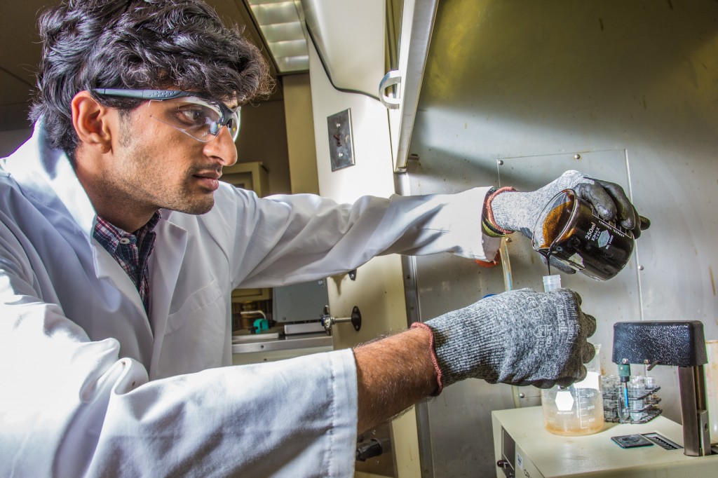 Graduate student Mukul Chavan pours a sample of heavy crude oil from the Kaparuk field on Alaska's North Slope. Chavan and other students in UAF's petroleum engineering program are using the samples to experiment with ways to recover more oil from existing fields by discovering properties such as viscosity, density and surface tension.