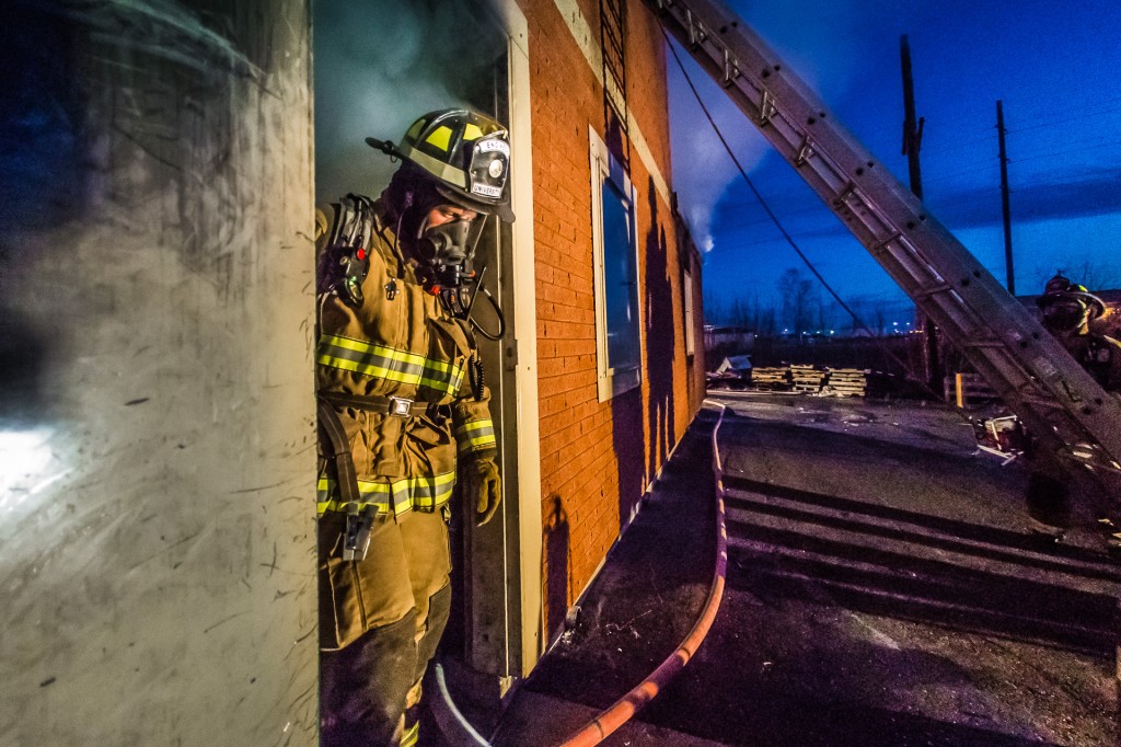 Student fire-fighting engineer Spencer McClean exits a burning building during a live training drill at the Fairbanks Fire Training Center. McClean was one of about 30 students participating in the University Fire Department's drill Oct. 22.