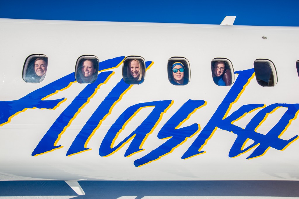 Members of the Nanook swim team peer out the windows Saturday, March 1, while touring one of the newest planes in the Alaska Airlines fleet, a Bombardier Q400 turboprop painted with the Alaska Nanooks and UAF logos.