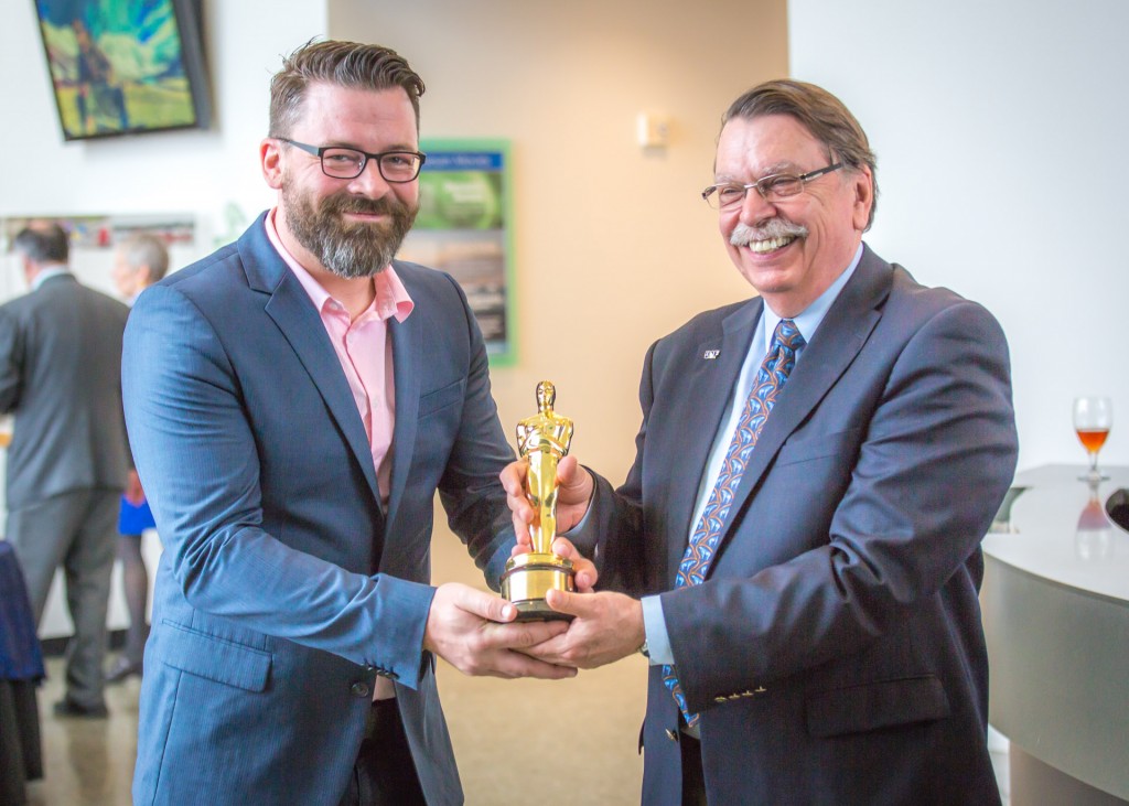 Ben Grossman, UAF's 2015 commencement speaker, lets Chancellor Brian Rogers handle the Oscar he won in 2012 during the annual Gold Dinner on May 9 honoring commencement guests and their families at the University of Alaska Museum of the North. 