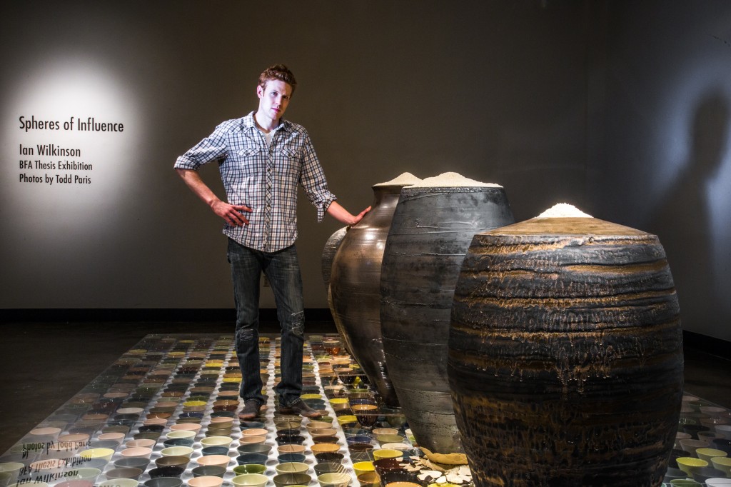 Art major Ian Wilkinson poses by one of his ceramic pieces in the UAF Fine Arts gallery.