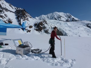 Photo by Regine Hock. Grad student Joanna Young drills a hole into the Susitna Glacier for a weather station and a melt stake to be installed in April 2012.