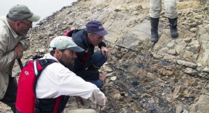 Photo by Roger Topp. Kevin May, Pat Druckenmiller and Paul McCarthy (left to right) inspecting an outcrop of Cretaceous rock along the Yukon River.