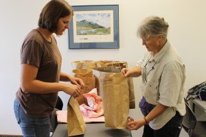 Darcy Etcheverry of UAF Cooperative Extension Service (left) helps Heather Koponen save turnip seeds.