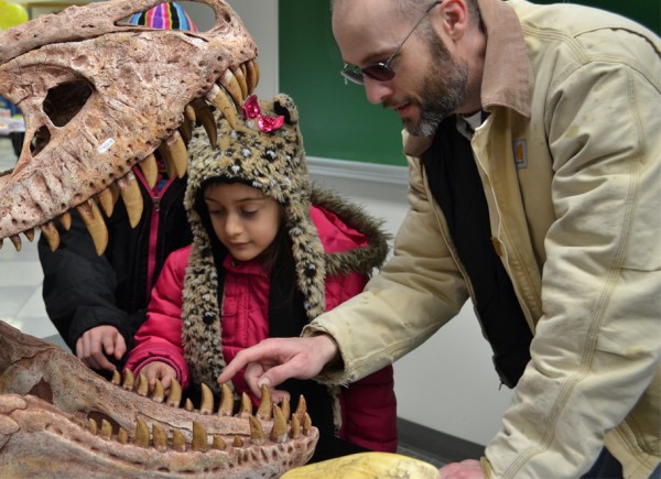 Matt Seymour and his daughter examine teeth of a dinosaur skull mold at last year's Science Potpourri.