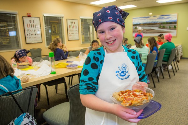 Melody Lackey, age 10, displays the pepperoni pizza she made during the Summer Sessions CAFE Youth Baking Blitz May 28 in the Hutchison kitchen.
