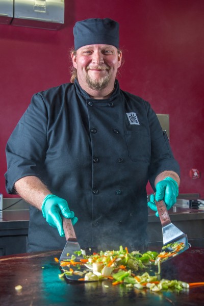Chad Richie cooks up some fresh vegetables on the Mongolian barbecue grill in Dine Forty-nine, the new dining facility in UAF's Wood Center.