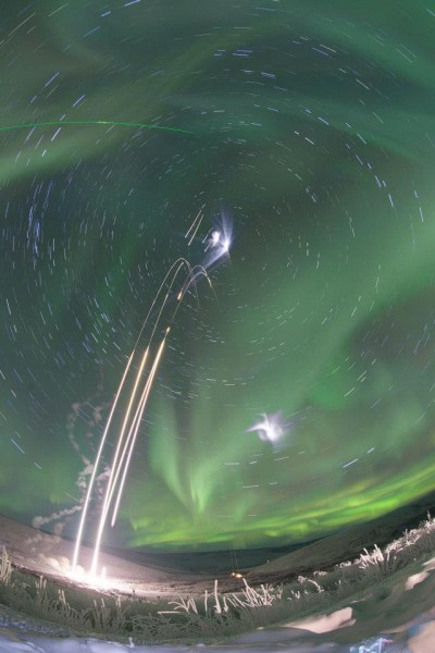 Photo by J. Adkins, NASA. This composite photograph shows four NASA sounding rocket launches from Poker Flat Research Range on the morning of Jan. 26, 2015. The swirls are stars. A vapor released by one of the rockets is visible as small white clouds. The green beam of a lidar system is visible in the upper left. The aurora is visible across the sky. 