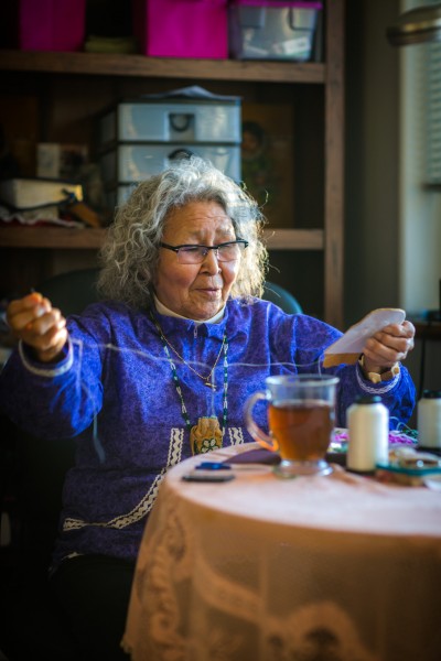 UAF photo by Todd Paris.  Elizabeth Fleagle practices beadwork in her Fairbanks home. The Inupiaq elder will receive an honorary doctorate next month at UAF's 94th commencement ceremony.