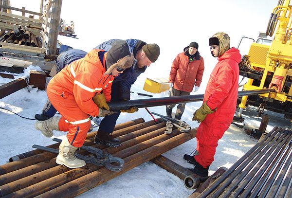 Photo by Igor Semiletov.  Members of the East Siberian Arctic Shelf scientific research expedition handle drill pipe used to reach subsea permafrost under fast ice.