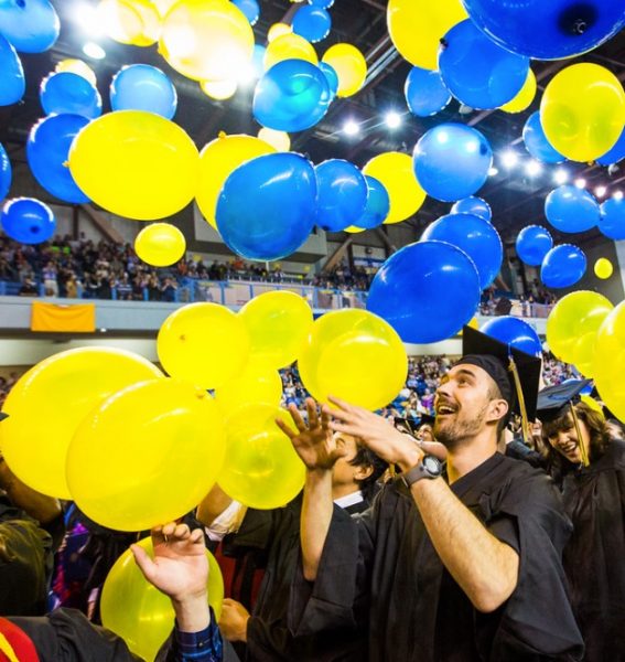 UAF photo by JR Ancheta.  Raleigh Bartholomew plays with the balloons after Commencement 2015.