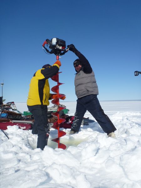 Photo by Guido Grosse, Alfred Wegener Institute. Chris Arp and Ben Jones drill into the ice of a shallow lake on Alaska's North Slope.