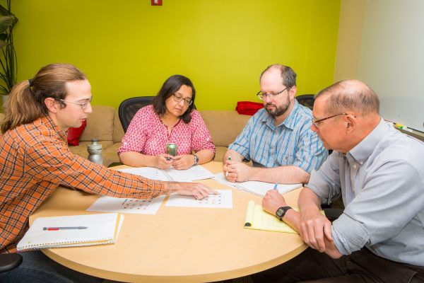 UAF photo by JR Ancheta.  Members of the dynamical downscaling team — Rick Lader, Uma Bhatt, Peter Bieniek, and John Walsh — discuss the intricacies of the model results at a weekly meeting.