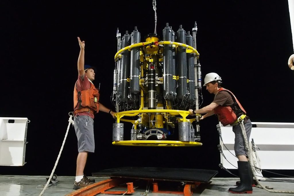 Andrew McDonnell photo.  Jim Burkitt, left, and Andrew McDonnell recover an instrument during night operations in the equatorial Pacific Ocean. . Click photo to download.