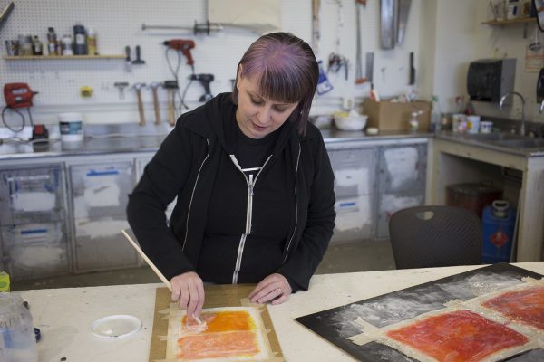 Photo by Alyssa Enriquez.  Annie Duffy demonstrates a mixed-media technique for her spring 2016 Advanced Painting class.