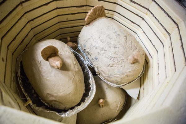 UAF photo by JR Ancheta.  Turkeys encased in clay are prepared for cooking inside a kiln at the University of Alaska Fairbanks ceramics studio.