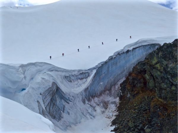 Joanna Young photo.  The Girls on Ice team hikes across a glacier. In addition to new technical skills and collaboration, participants are exposed to the wonders and beauty of nature in a way to which few people from their age groups or communities have access.