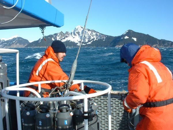 Photo by Sarah Thornton.  Graduate students prepare to deploy the water bottle and sensor package to record conductivity, temperature and depth at a point on the Seward Line as part of the Global Ocean Ecosystem Dynamics program.