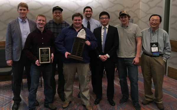 Photo courtesy of Alan Lipka. UAF's winning team at a mine design competition in mid-February pose with the championship trophy. From right, Professor Hong Kim; students Blaze Brooks, Nori Niibu, Alan Lipka, Ethan Trickey, Cole Snodgress and Jordan Hildreth; and competition chairman Andrew Storey.