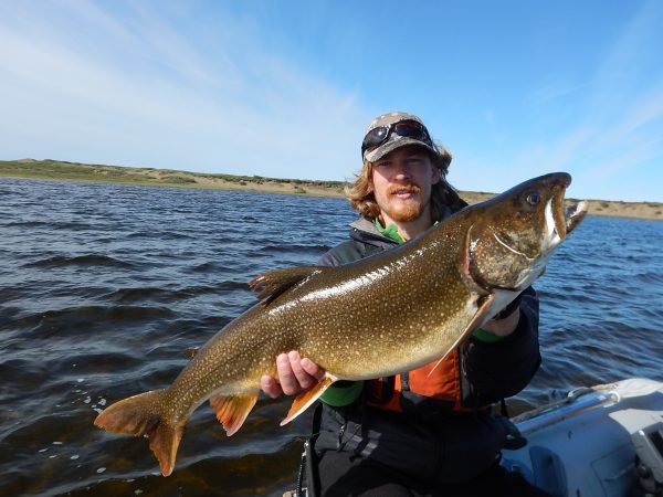  Photo by Lydia Smith.. Kurt Heim shows a lake trout he caught in the Fish Creek watershed on the Arctic Coastal Plain.