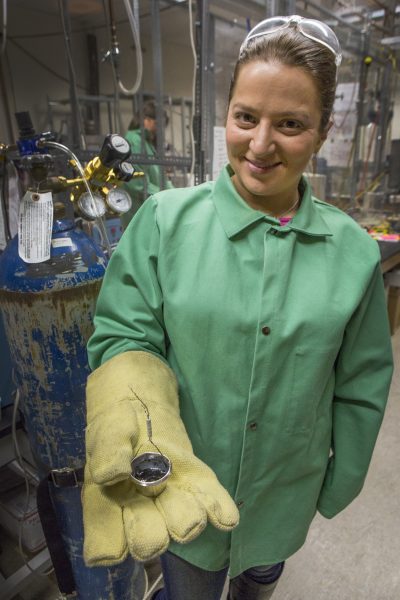 Photo by Meghan Murphy. Geoscientist Sarah Black holds a handful of simulated Martian rock that she created and will later destroy as part of an experiment involving hydrothermal systems.