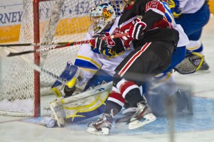 Senior goalie Scott Greenham takes a big hit from UNO's Brock Montpetit in the opening minutes of the Nanooks' 4-1 win in the Brice Alaska Goal Rush tournament.