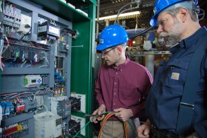 Tom Johnson, left, and Dave Light, researchers with UAF's Alaska Center for Energy and Power, inspect the newly installed "Green Machine" designed to recover waste heat from diesel engines in the Atkinson Building. 